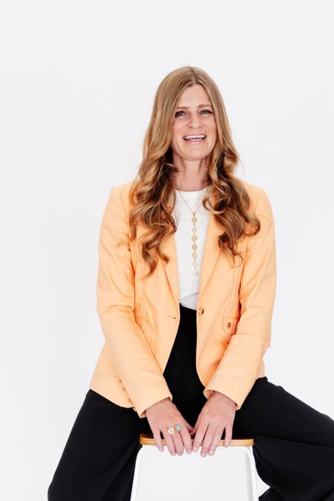 Allie Pepper smiling in a peach blazer