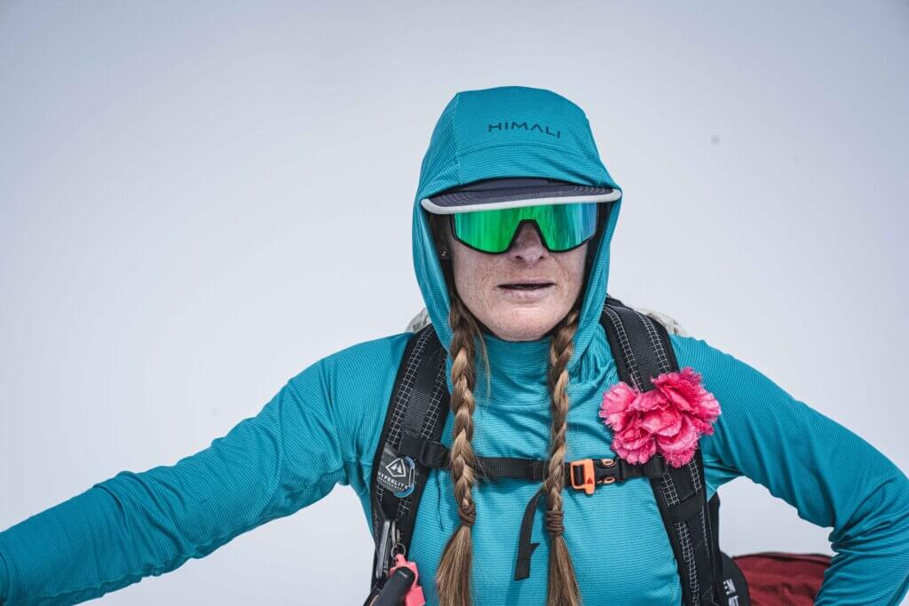 Allie Pepper on Manaslu wearing a turquoise hood and mirrored sunglasses
